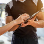 Closeup and crop fitness trainer is introducing exercise program to young female clients
